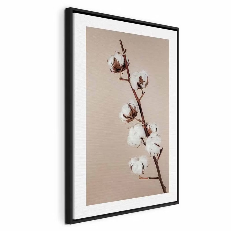 Softness of cotton vertical – svart ram. En tunn brun kvist med vita bomullsbollar framträder mot en varm, beige bakgrund.