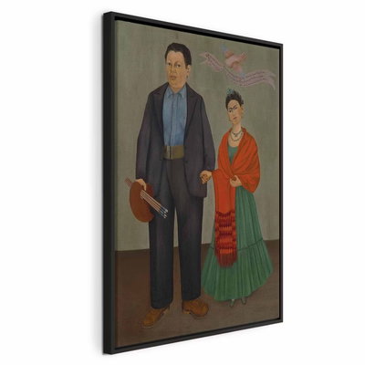 Frida kahlo frida and diego – svart ram. En man i mörk kostym och en kvinna i grön kjol och röd sjal står tillsammans mot en dämpad bakgrund.