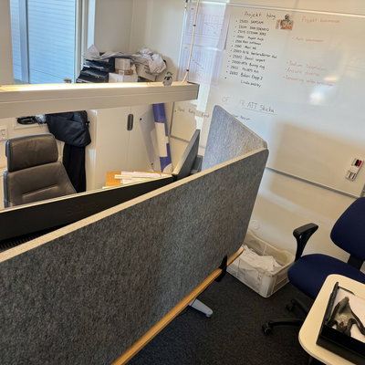 Bulletin Desk Screen: A gray desk screen mounted on a desk for a quieter work environment