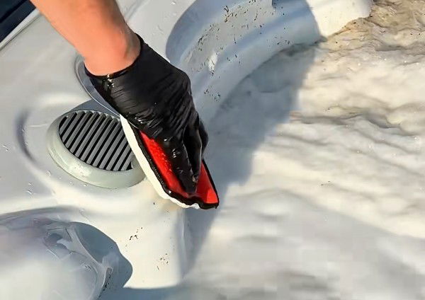 Skrubbar spabadets kanter med scrub-pad
