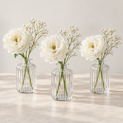Tre låga blomsterpunkter – pion och gypsophila i klarglas