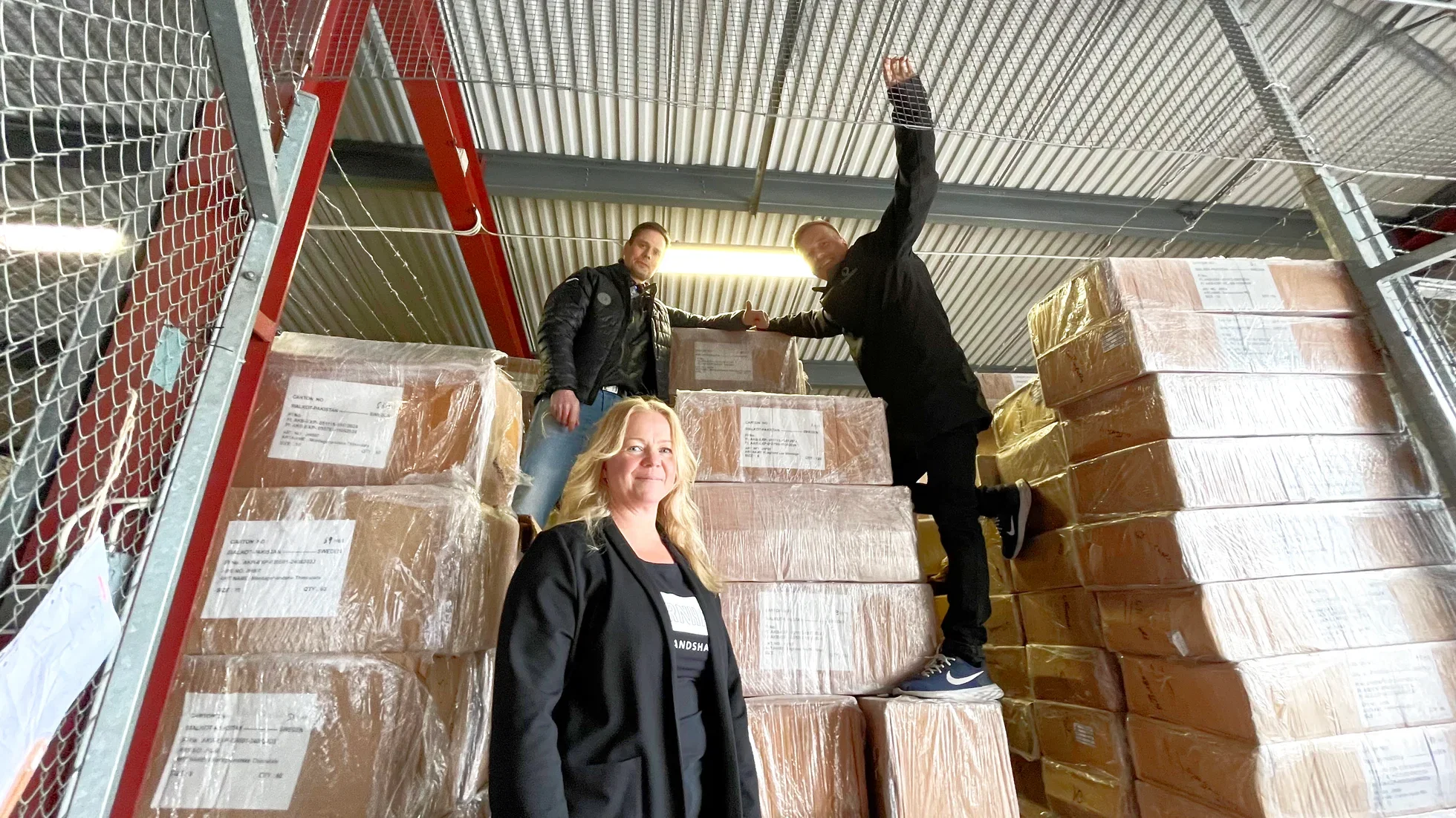 JÄRNHAND-teamet i lagret bland kartonger med arbetshandskar